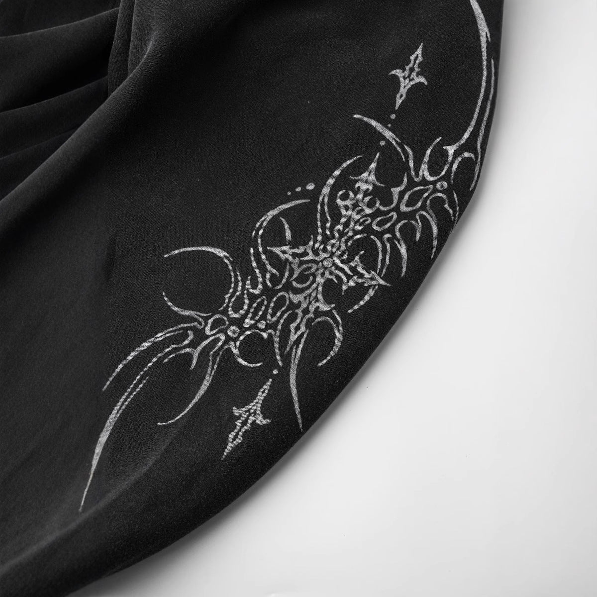 トライバルデザインプリントが施されたHigh landブラックパーカーの袖アップ